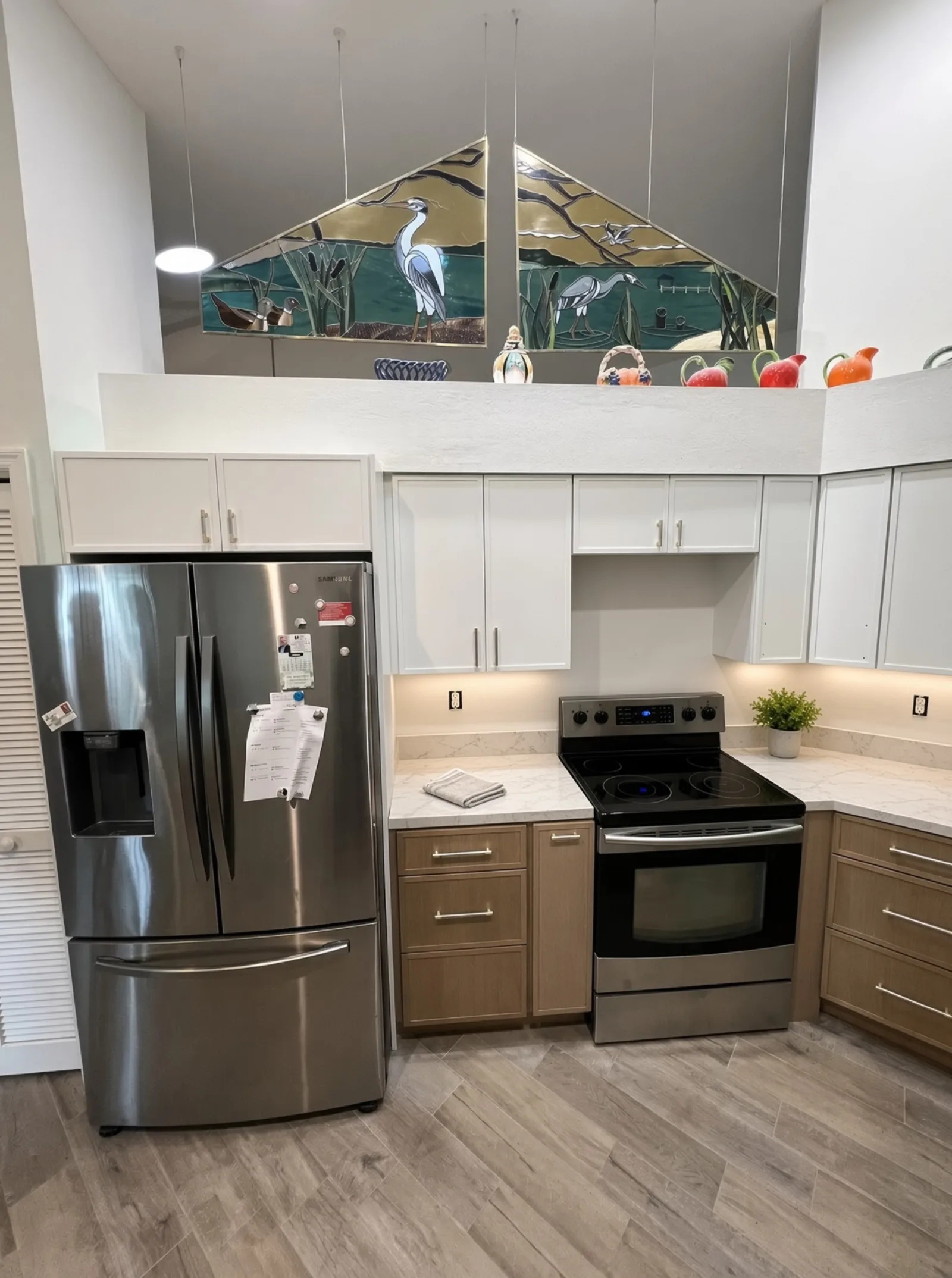 Two-tone kitchen with natural wood lower cabinets and range in Tampa